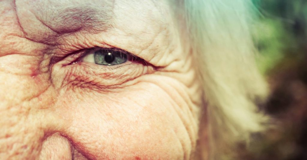 Close-up of an older woman's smiling eye, illustrating how much of longevity is genetic